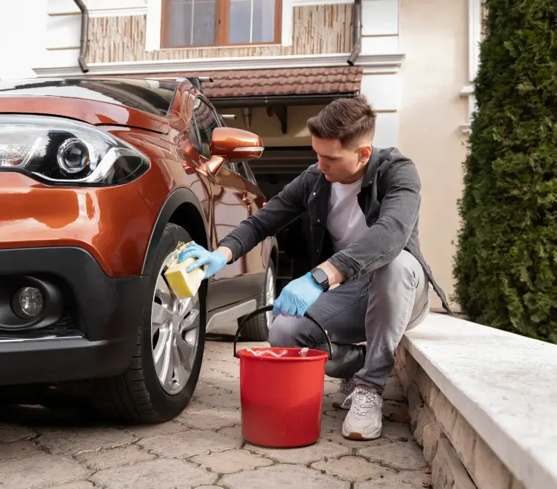 Lavage auto à domicile Monceaux-en-Bessin : professionnel intervenant sur un véhicule